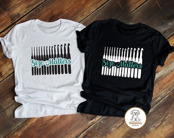 May include: Two t-shirts with the text "Size Matters" and a row of crochet hooks. The t-shirts are white and black.