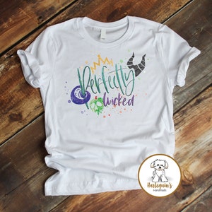 K&ouml;nnte beinhalten: Wei&szlig;es T-Shirt mit einem Aquarell-Design mit einer Krone, H&ouml;rnern und dem Text "Perfectly Wicked".