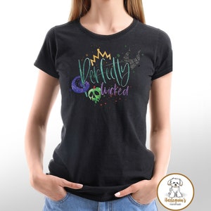 K&ouml;nnte beinhalten: Schwarzes T-Shirt mit einer gr&uuml;nen, violetten und goldenen Grafik, auf der "Perfectly Wicked" mit einer Krone, einem Apfel und einem Horn steht.