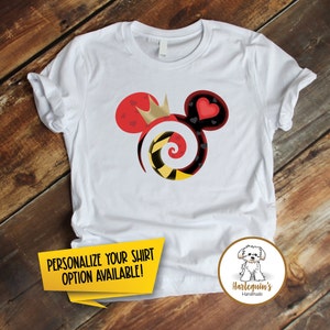 K&ouml;nnte beinhalten: Wei&szlig;es T-Shirt mit einem roten, schwarzen, gelben und goldenen Mickey-Mouse-Motiv mit einer Krone, Herzen und einer Spirale. Der Text "PERSONALISIERE DEIN SHIRT OPTION VERF&Uuml;GBAR!" befindet sich auf einem gelben Banner am unteren Rand des Bildes. Der Text "Harlequin's Handmade" befindet sich auf einem braunen Kreis mit einem wei&szlig;en Hund darin.