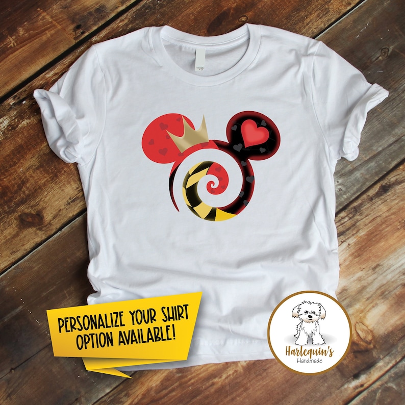 K&ouml;nnte beinhalten: Wei&szlig;es T-Shirt mit einem roten, schwarzen, gelben und goldenen Mickey-Mouse-Motiv mit einer Krone, Herzen und einer Spirale. Der Text "PERSONALISIERE DEIN SHIRT OPTION VERF&Uuml;GBAR!" befindet sich auf einem gelben Banner am unteren Rand des Bildes. Der Text "Harlequin's Handmade" befindet sich auf einem braunen Kreis mit einem wei&szlig;en Hund darin.