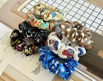 May include: Five colorful hair scrunchies in a variety of patterns, including floral, polka dot, and stars and stripes.