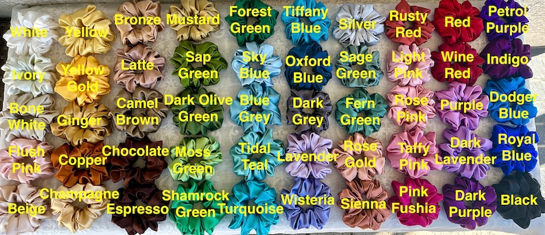May include: A collection of 40 scrunchies in various colours and fabrics, including beige, white, yellow, brown, green, blue, purple, pink, red, and black. The scrunchies are arranged in a grid pattern and labelled with their corresponding colour names.