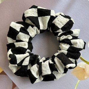May include: Black and white checkered fabric scrunchie hair tie.