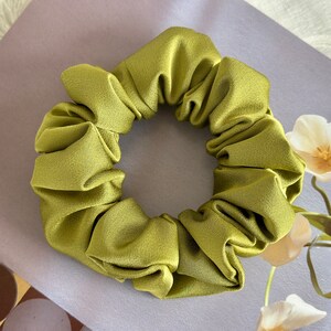 May include: A green satin scrunchie for hair.