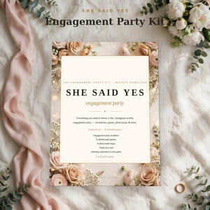 May include: A rectangular engagement party kit sign featuring the text "SHE SAID YES" in black, surrounded by a border of soft pink and peach roses and white baby's breath flowers on a cream background with gold accents.
