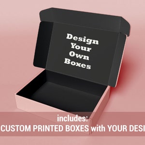 May include: An open pink cardboard box with a black interior. The box is labeled "Design Your Own Boxes" and includes 25 custom printed boxes with your design.