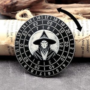 May include: A circular black and silver pendant with a witch illustration. The pendant has a numbered outer ring. The witch is depicted wearing a hat and cloak. A unique accessory, approximately 4 cm in diameter.