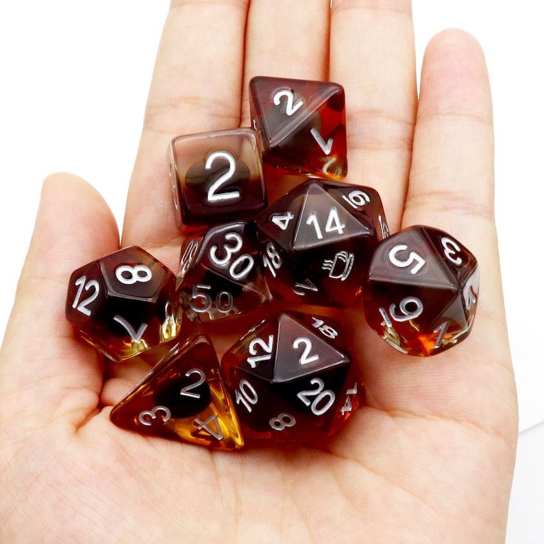 May include: A set of eight brown and clear dice with white numbers. The dice are in a variety of shapes and sizes.