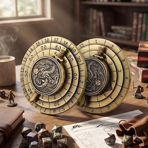 Puede incluir: Dos bandejas de dados de juego de color latón antiguo con un diseño de dragón. Cada bandeja tiene un diseño circular con números alrededor del borde. Las bandejas están sobre una mesa de madera con dados y una hoja de Dungeons & Dragons.