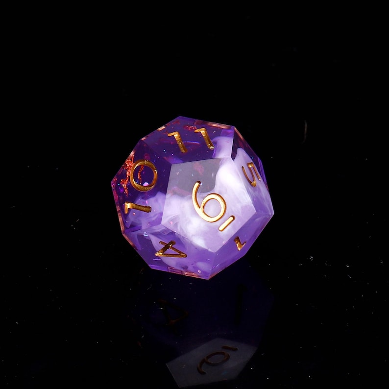 May include: A purple and white d6 dice with gold numbers. The dice has a swirl pattern and is made of clear plastic.