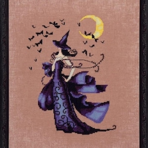 May include: A framed cross-stitch embroidery featuring a figure wearing a purple gown and a pointed hat, standing against a dusty rose background. A yellow crescent moon and a flock of black bats are stitched above the figure in the dark scene.