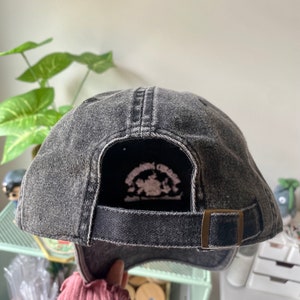 May include: Black denim baseball cap with an adjustable strap and a small embroidered logo on the back. The logo features a horse and the text "Springbrook Creek".