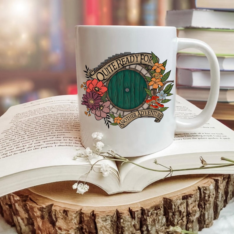 May include: White ceramic mug with a green door illustration surrounded by flowers and the text "Quite Ready For Another Adventure".