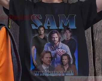 May include: A black t-shirt with a vintage-style graphic of the characters from the TV show "Supernatural". The graphic features the words "Sam Winchester" and images of the four main characters.