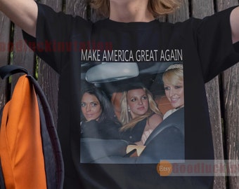 May include: A black t-shirt with a white print of three women in a car. The text "MAKE AMERICA GREAT AGAIN" is printed above the image.