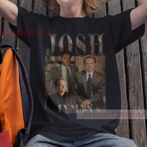 May include: A black t-shirt with a vintage-style graphic of a group of men with the text "Josh Lyman" printed on it.