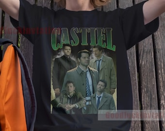 May include: A black t-shirt with a vintage-style graphic of the characters from the TV show "Supernatural". The graphic features the characters Castiel, Dean, Sam, and Jack. The text "CASTIEL" is printed in green letters above the graphic.