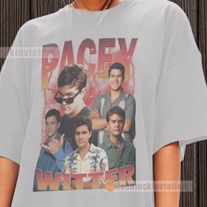 May include: An oversized grey t-shirt featuring a vintage-style graphic of a group of men with the text "Pacey Witter" printed on the front.