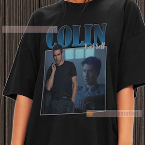 May include: Black t-shirt with a vintage-style graphic of Colin Farrell. The graphic features two images of Colin Farrell, one in a black shirt and the other in a blue shirt. The text "COLIN Farrell" is printed in blue above the images.