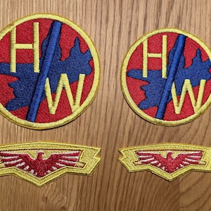 May include: Two red, white, and blue embroidered patches with the letters "HW" and a blue shape. Two yellow embroidered patches with a red eagle design.