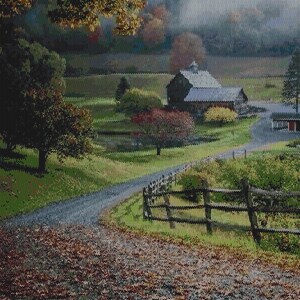 Puede incluir: Un paisaje con un camino de grava cubierto de hojas de otoño que conduce a un granero oscuro. El entorno rural incluye una valla de madera, colinas verdes, árboles con follaje otoñal y un bosque brumoso en el fondo.