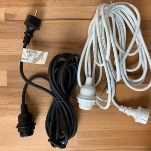 May include: Two electrical cords with black and white plugs and cords. The black cord has a label that reads "CE" and "220-240V~ 50Hz 100W".
