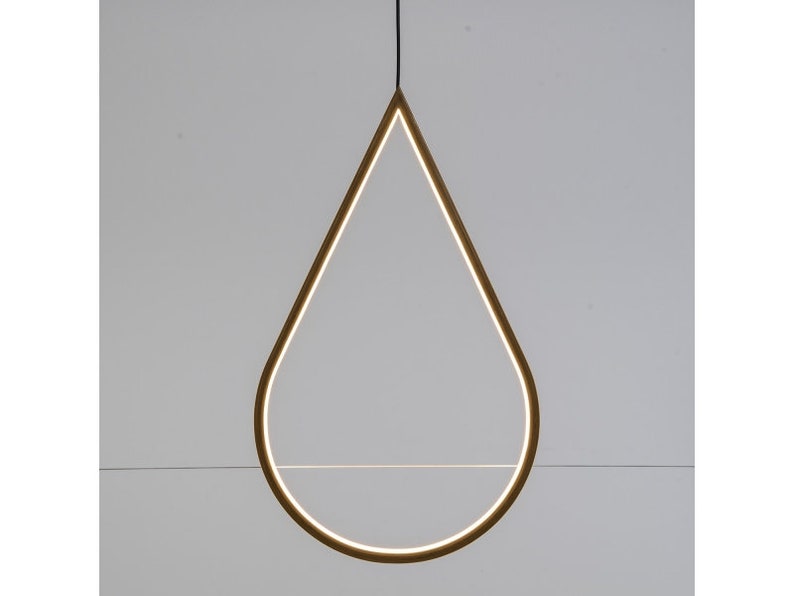 May include: A gold-colored teardrop-shaped pendant light fixture with a thin, horizontal shelf inside the teardrop.