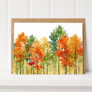 May include: A rectangular greeting card featuring a watercolor illustration of a dense forest landscape. The trees display vibrant autumn foliage in shades of orange, red, yellow, and green, set against a clean white background on the card face.