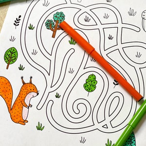 May include: A black and white maze with a squirrel, a tree, and an acorn. The maze is designed for children to help the squirrel find the acorn. The maze is printed on white paper.