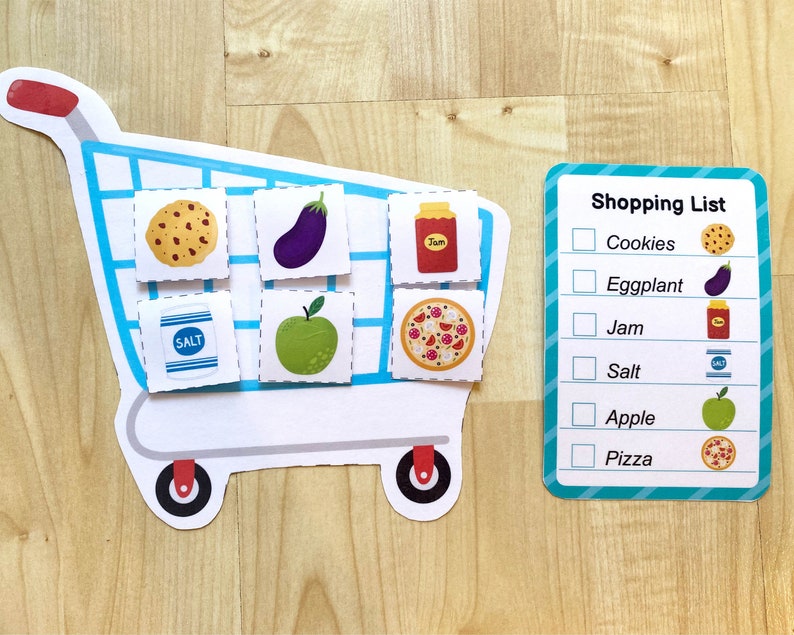 May include: A blue shopping cart with various food items, including cookies, eggplant, jam, salt, an apple, and pizza. A shopping list with checkboxes is on the right side of the image. The list includes the items: Cookies, Eggplant, Jam, Salt, Apple, and Pizza.