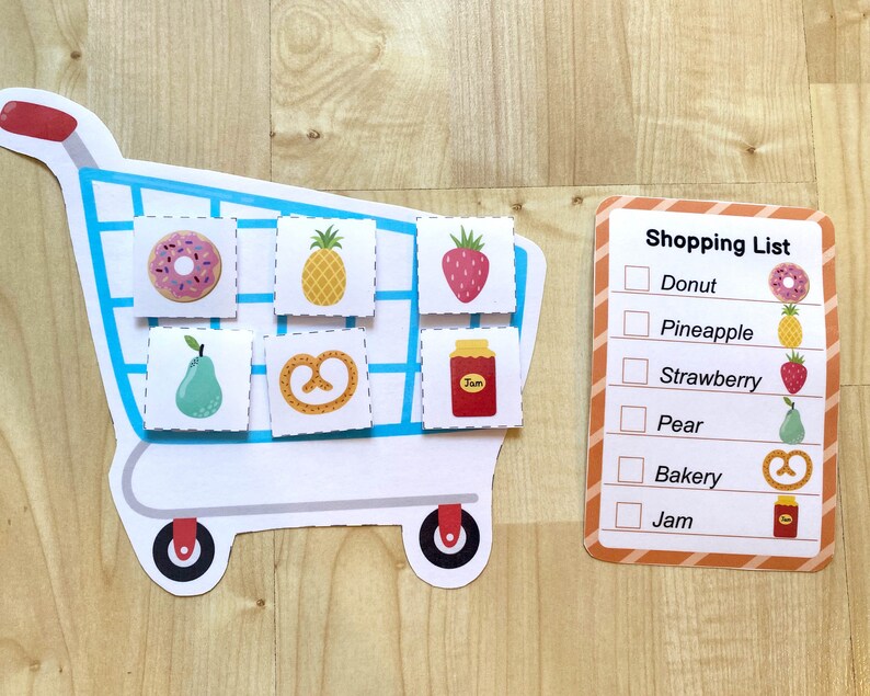 May include: A blue shopping cart with a donut, pineapple, strawberry, pear, pretzel, and jam. A checklist with the items on the cart is on the right side of the image. The checklist says "Shopping List" and has checkboxes next to the words "Donut", "Pineapple", "Strawberry", "Pear", "Bakery", and "Jam".