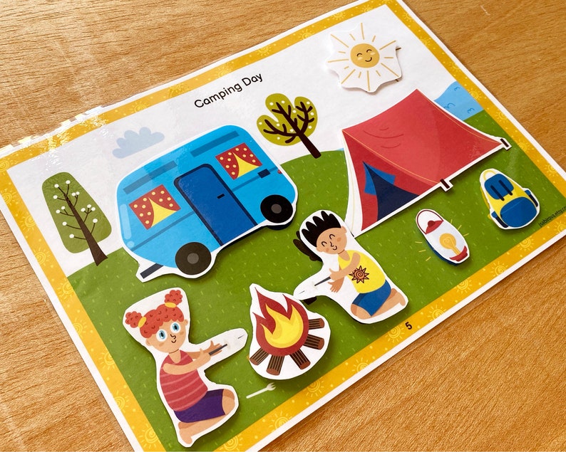 Puede incluir: Una ilustraci&oacute;n colorida de una escena de camping con una caravana azul, una tienda de campa&ntilde;a roja, una fogata, dos personas y un sol. El texto "Camping Day" est&aacute; en la parte superior de la imagen.