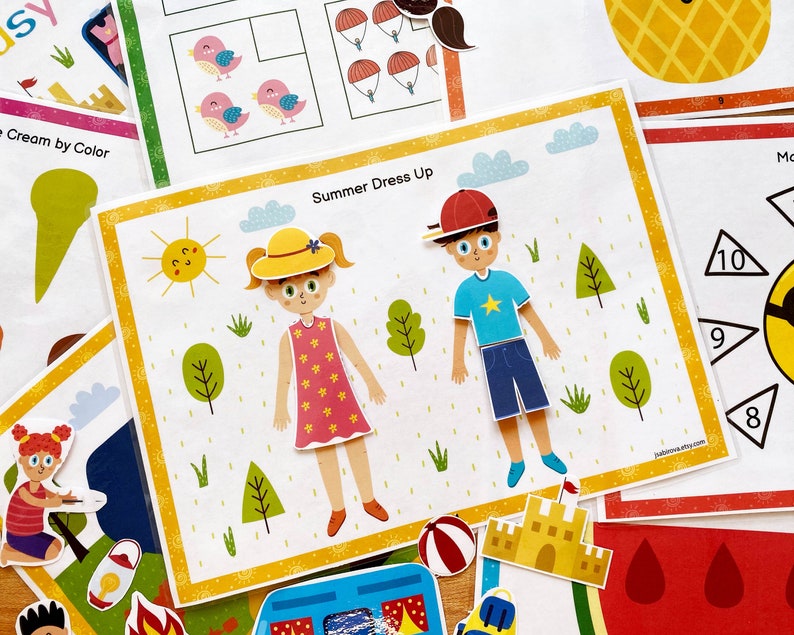 Puede incluir: Una actividad de vestir de verano imprimible para ni&ntilde;os. La actividad presenta a dos ni&ntilde;os, uno con un sombrero amarillo y un vestido rosa, y el otro con un sombrero rojo y pantalones cortos azules. La actividad tambi&eacute;n incluye un sol, nubes y hierba.