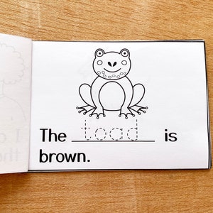 Może przedstawiać: Czarno-biała ilustracja żaby z tekstem "The toad is brown."
