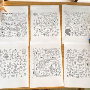 May include: Six black and white printable maze activity sheets. The mazes feature various themes, including a hungry bear, a dinosaur, a hedgehog, a squirrel, a fish, and a Santa Claus.