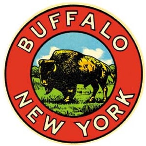 May include: A vintage-style round sticker with a red border and the words "Buffalo New York" in white lettering. The center of the sticker features a cartoon illustration of a brown buffalo standing in a green field with a blue sky and white clouds in the background.