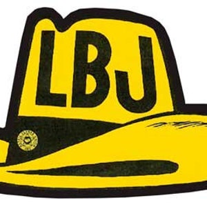 May include: A yellow cowboy hat with a black band and the letters "LBJ" in black on the front.