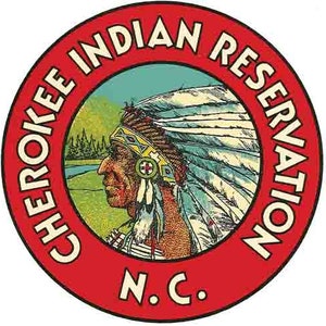 Może przedstawiać: Czerwone koło z tekstem "Cherokee Indian Reservation N.C." wokół krawędzi. Wewnątrz koła znajduje się rysunek rdzennego Amerykanina w nakryciu głowy.