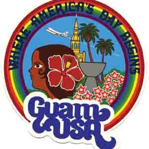 May include: A colorful circular sticker with a rainbow border. The sticker features a cartoon illustration of a woman's face with a red hibiscus flower in her hair. The text "Where Americans Day Begins" is written in a circle around the image. The text "Guam USA" is written in a large, stylized font at the bottom of the sticker.