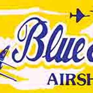 May include: A yellow banner with the text "Blue Angels AIRSHOW" in blue cursive lettering.  Four blue jet airplanes are flying in formation against a white cloud background.