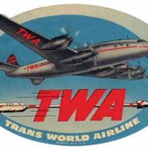 Pode incluir: Um adesivo vintage do logotipo da TWA Trans World Airline que apresenta um oval azul e branco com uma seta vermelha e o logotipo da TWA em vermelho. O adesivo também apresenta um avião prateado com o logotipo da TWA na cauda.