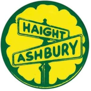 May include: A green and yellow circular sticker with the words "HAIGHT ASHBURY" printed on it. The words are in a black font and are arranged in a cross shape.
