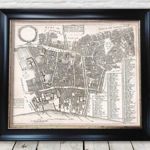 May include: Framed vintage map print of Farringdon Ward, London, with detailed street layouts and text. The black frame surrounds the antique map, which is printed in black and white. The map includes text such as "Part of St. Andrews" and "Part of the Charter House."