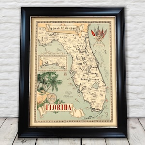Op de afbeelding: Vintage kaart van Florida met een gedetailleerde illustratie van de steden, dorpen en bezienswaardigheden van de staat. De kaart is ingelijst in zwart en heeft een decoratieve rand met een kompas en vlaggen.