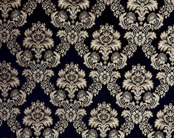 May include: A black fabric with a gold and silver damask pattern. The pattern features intricate floral designs and swirls.