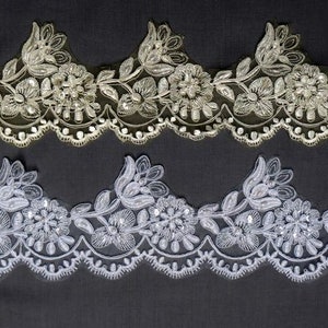 May include: Two rows of white and ivory beaded lace trim with scalloped edges. The top row is ivory and the bottom row is white.