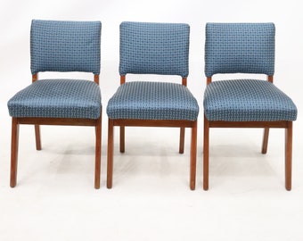 May include: Three blue upholstered chairs with wooden legs. The chairs have a geometric pattern on the fabric.