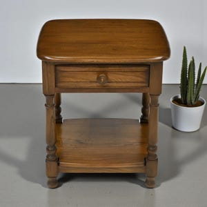 May include: A white ceramic mug with a black handle and the text "But First, Coffee" in a handwritten style. The mug is on a white surface. The mug is 10 cm tall.