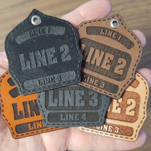 May include: Five leather patches with stitched edges. The patches are brown and black and have the text "LINE 1", "LINE 2", "LINE 3", "LINE 4" and "LINE 2" on them.